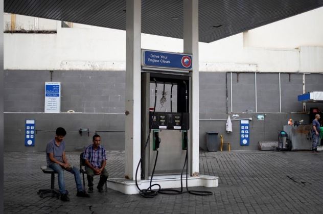 اثنان من العاملين بمحطة وقود في بيروت في صورة بتاريخ 23 أكتوبر  2019. تصوير: الكيس قنسطنطنيدس - رويترز.